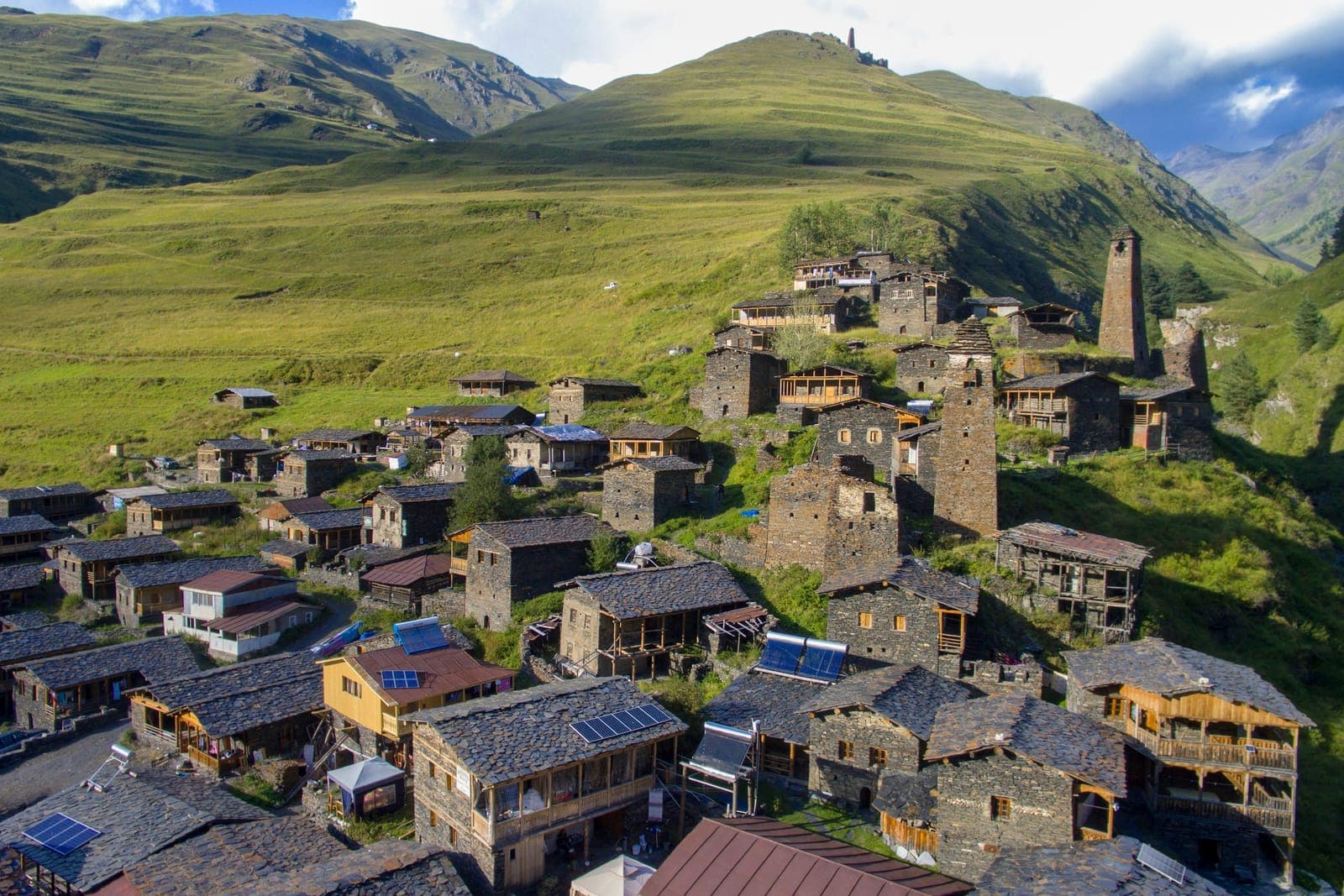 图舍蒂达尔特洛村的石塔和石板屋顶房屋,沿着绿色山坡层层而上